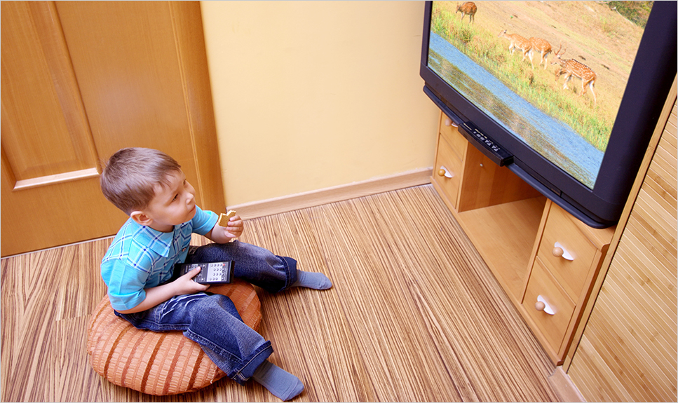Niño viendo de cerca la televisión.