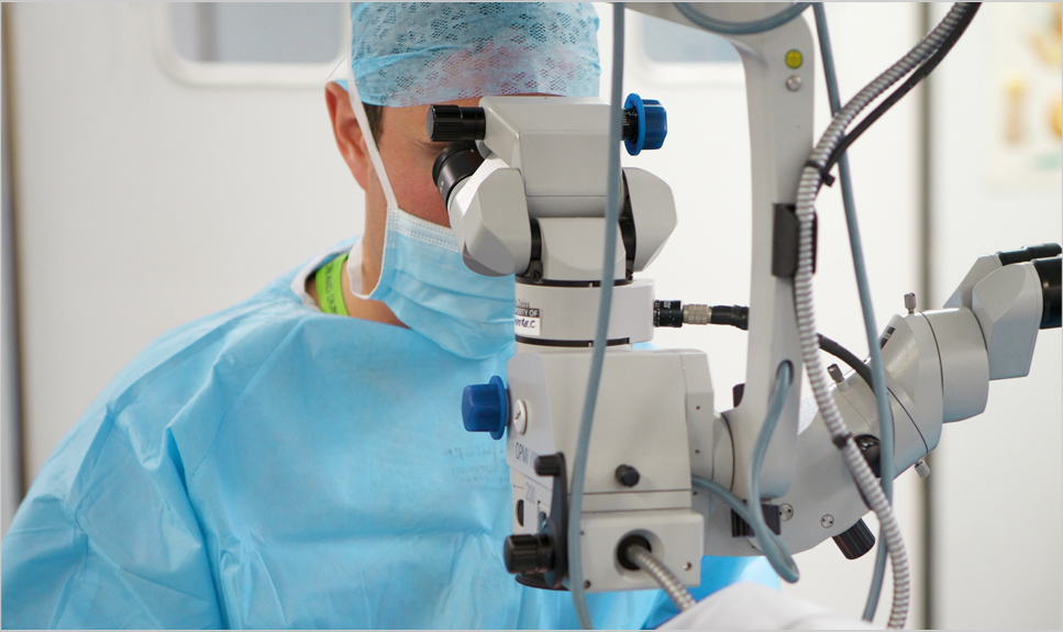 Médico oftalmólogo realizando una cirugía de ojo.