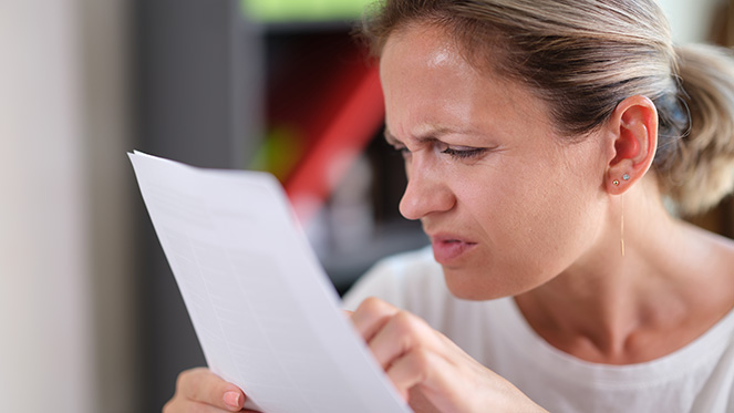 Mujer con dificultades para leer de cerca un libro