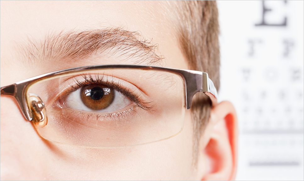 Acercamiento del ojo de un niño con lentes.