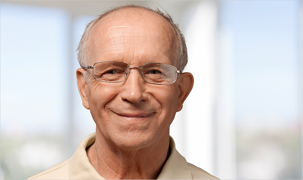 Hombre sonriendo con sus lentes bifocales.