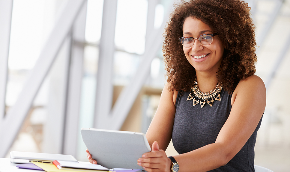 Mujer feliz con lentes usando un Ipad.