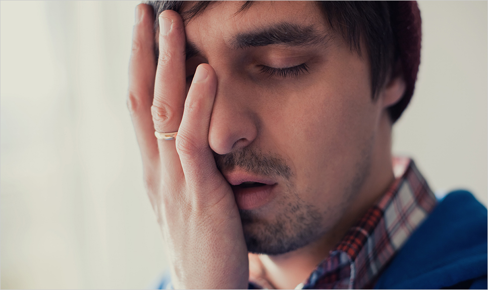 Hombre tocándose el ojo por dolor.